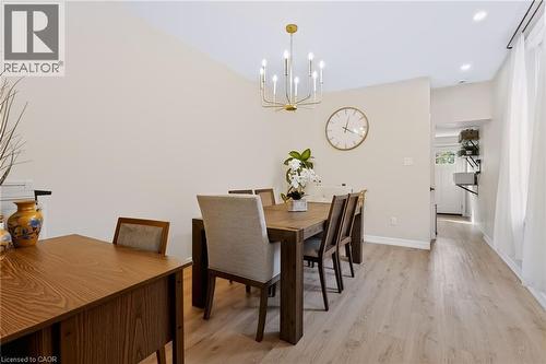 Vaulted ceiling, gold-finish chandelier, recessed lighting, wood-finish flooring, and white walls - 34 Baillie Street, Hamilton, ON 