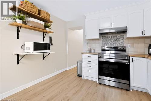 Light wood-finish flooring complements the white cabinetry - 34 Baillie Street, Hamilton, ON 