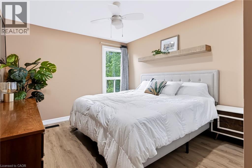 Wood-finish flooring, ceiling fan, window with exterior scenery, built-in wall shelf, and upholstered headboard - 34 Baillie Street, Hamilton, ON