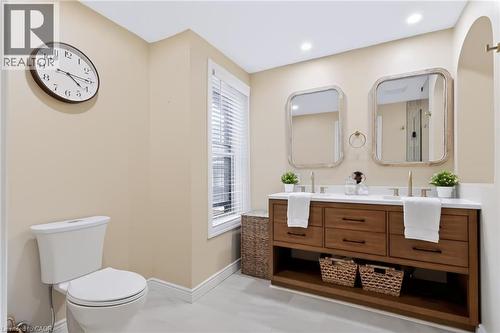 Dual vanity with wood-finish cabinetry, white countertop, and gold-tone fixtures - 34 Baillie Street, Hamilton, ON 