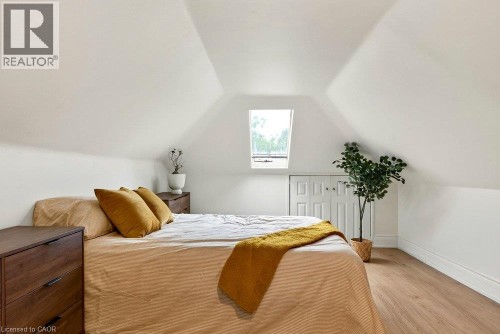 Sloped ceiling design, skylight, laminate flooring, white paneled wall, and a built-in storage area - 136 Weir Street N, Hamilton, ON 