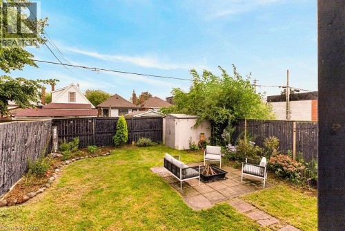 Expansive backyard featuring a manicured lawn, established landscaping, and a paver patio - 136 Weir Street N, Hamilton, ON 