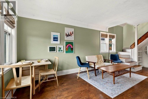Laminate flooring throughout, light green wall finishes, and white trim - 136 Weir Street N, Hamilton, ON 