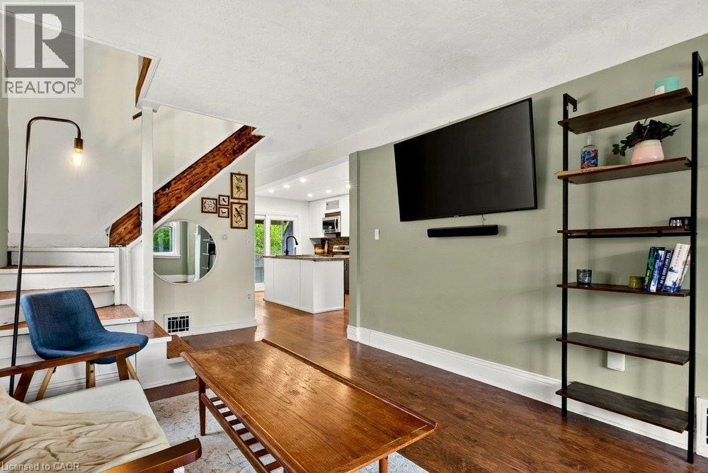 Laminate flooring, painted interior walls, staircase with exposed wood beam, recessed lighting, and built-in shelving - 136 Weir Street N, Hamilton, ON