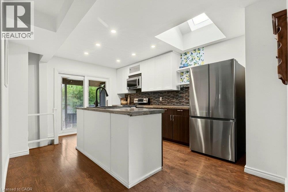 Kitchen featuring laminate flooring, recessed lighting, and a skylight - 136 Weir Street N, Hamilton, ON