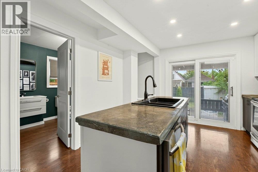 Central island with a concrete countertop and integrated black sink - 136 Weir Street N, Hamilton, ON
