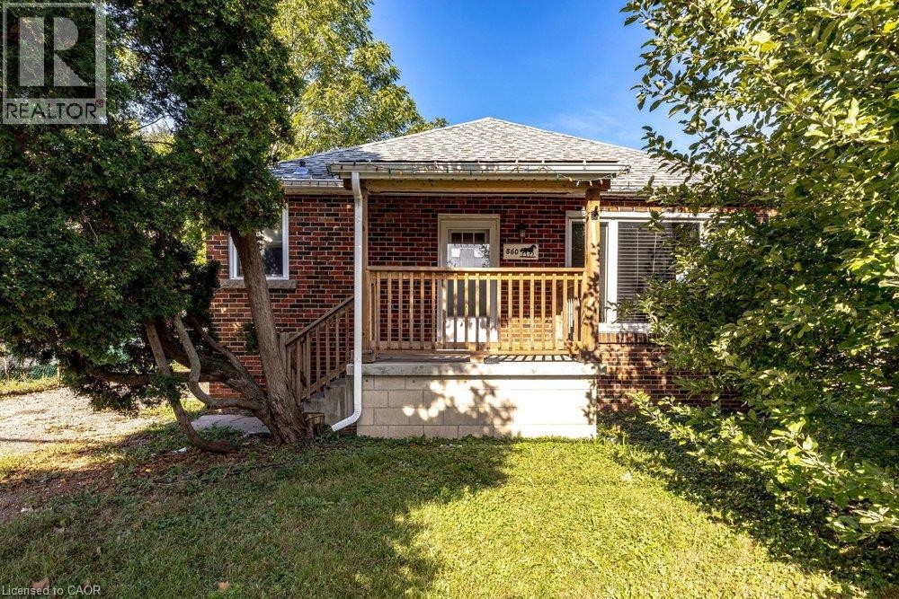 Brick exterior with a covered front porch featuring wood railings - 860 Garth Street, Hamilton, ON