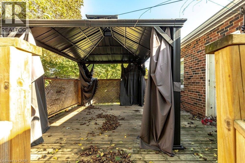 Wood-plank outdoor deck with a dark metal gazebo structure and attached privacy screens - 860 Garth Street, Hamilton, ON