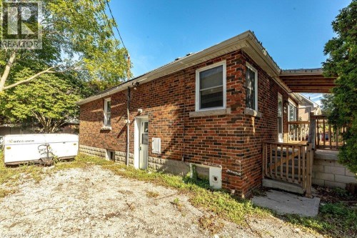 Brick exterior with white trim, wood deck, and partial covered porch - 860 Garth Street, Hamilton, ON 