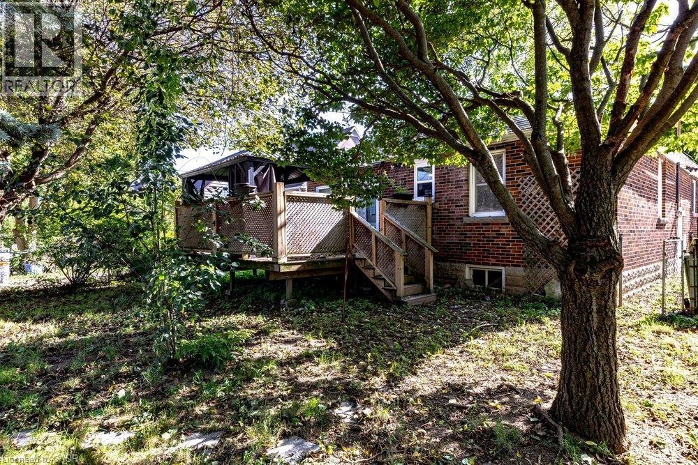 Rear yard featuring a wooden deck with railing, stairs, and a partial gazebo - 860 Garth Street, Hamilton, ON