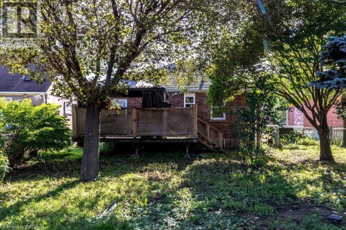 Rear exterior with brick facade, wood deck, and mature trees - 860 Garth Street, Hamilton, ON 