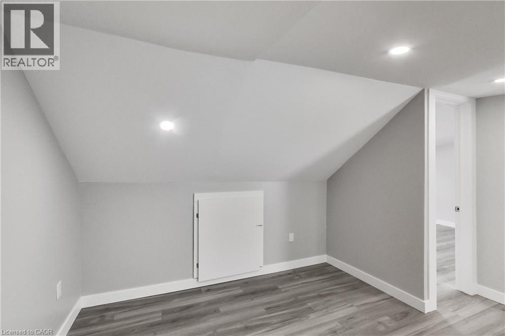 Recessed lighting, sloped ceiling, wood-finish flooring, built-in storage cabinet, and white trim - 229 Parkdale Avenue N, Hamilton, ON