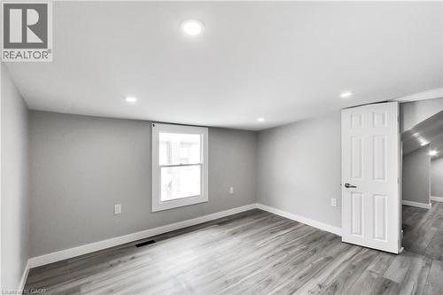 Recessed ceiling lighting, wood-finish flooring, white trim, and a paneled interior door - 229 Parkdale Avenue N, Hamilton, ON 