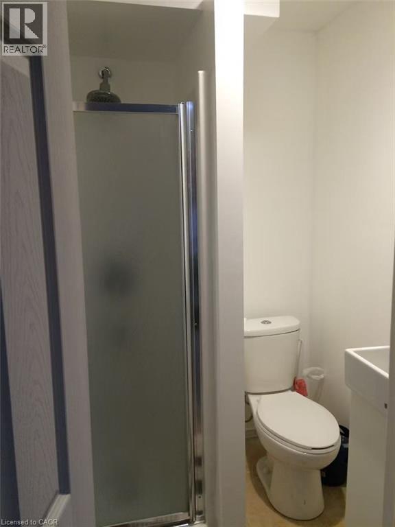 Frosted glass shower enclosure with chrome framing, white toilet, and pedestal sink - 95 Resurrection Drive, Kitchener, ON
