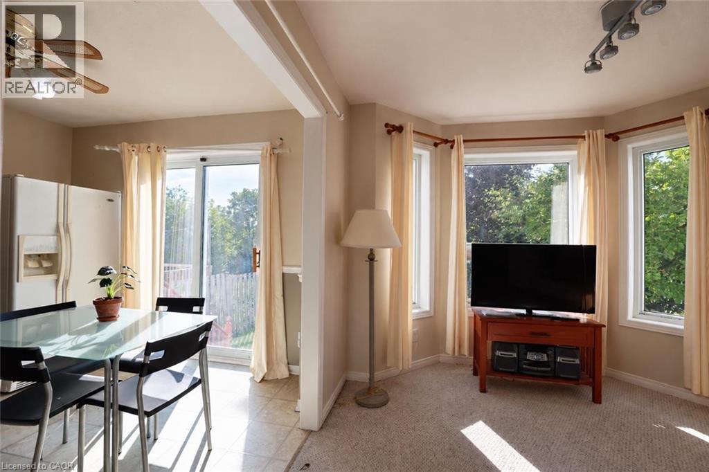 Open concept living area with a bay window, track lighting, and a ceiling fan - 95 Resurrection Drive, Kitchener, ON
