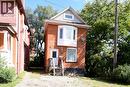 Brick exterior with a white bay window, white-framed windows, and a white entry door - 734 King Street W, Hamilton, ON 