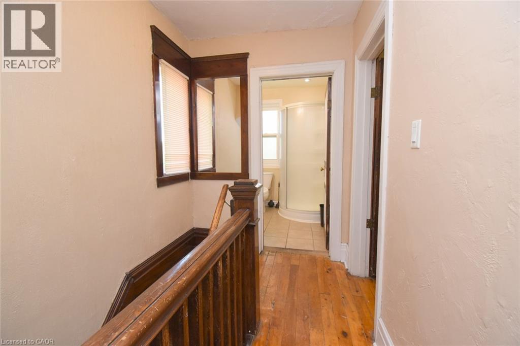 Wood-finish flooring throughout the hallway - 734 King Street W, Hamilton, ON