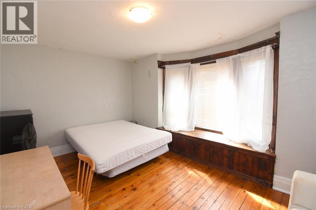Hardwood flooring, curved bay window, built-in window seating, flush mount ceiling light - 734 King Street W, Hamilton, ON