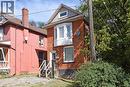 Brick exterior featuring a bay window with white trim, a gabled roofline, and a prominent front entrance - 734 King Street W, Hamilton, ON 