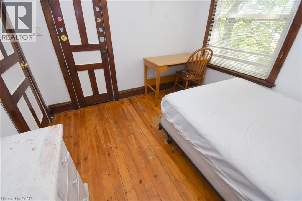 Wood-finish flooring with white walls and a large window - 734 King Street W, Hamilton, ON