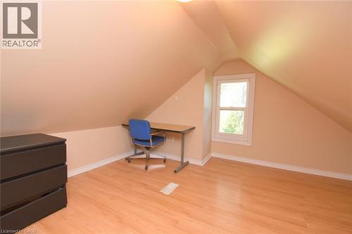Sloping ceiling details, natural light from a single window, and wood-finish flooring - 734 King Street W, Hamilton, ON 