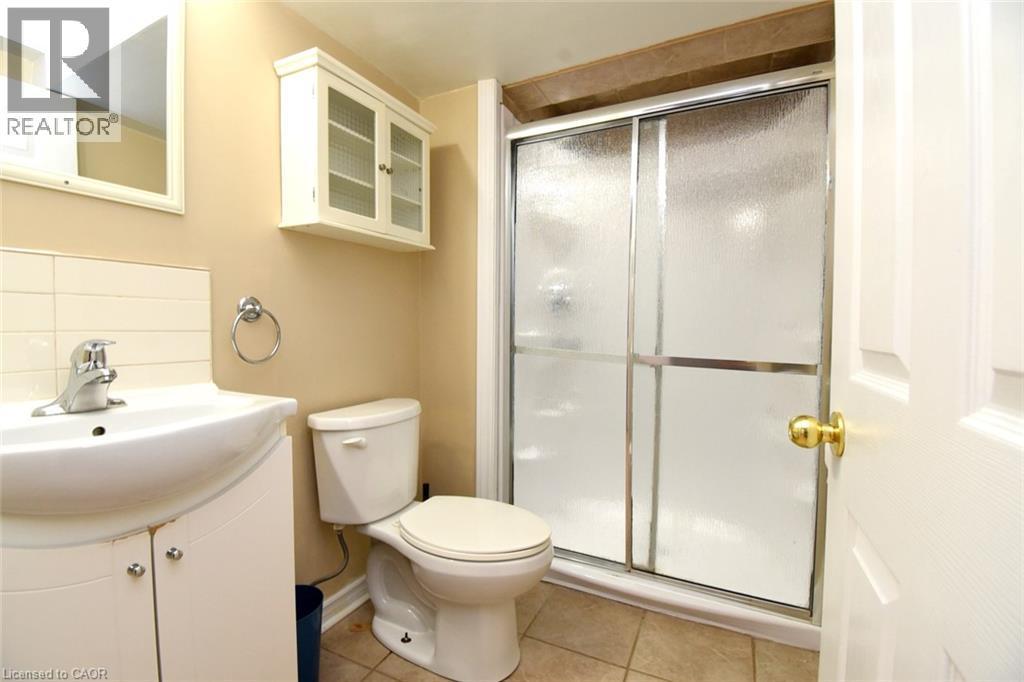 White vanity with integrated sink, chrome-finish faucet, and ceramic tile flooring - 734 King Street W, Hamilton, ON