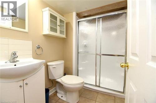 White vanity with integrated sink, chrome-finish faucet, and ceramic tile flooring - 734 King Street W, Hamilton, ON 