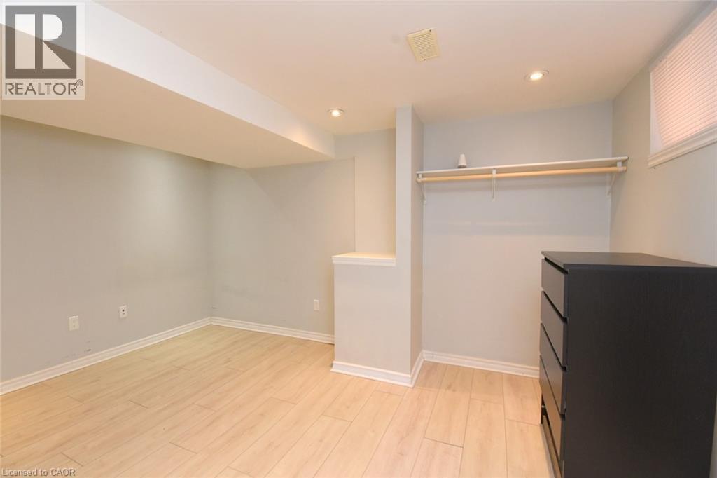 Recessed ceiling lighting, light wood-finish flooring, a window with blinds, and an open closet area with a hanging rod - 734 King Street W, Hamilton, ON