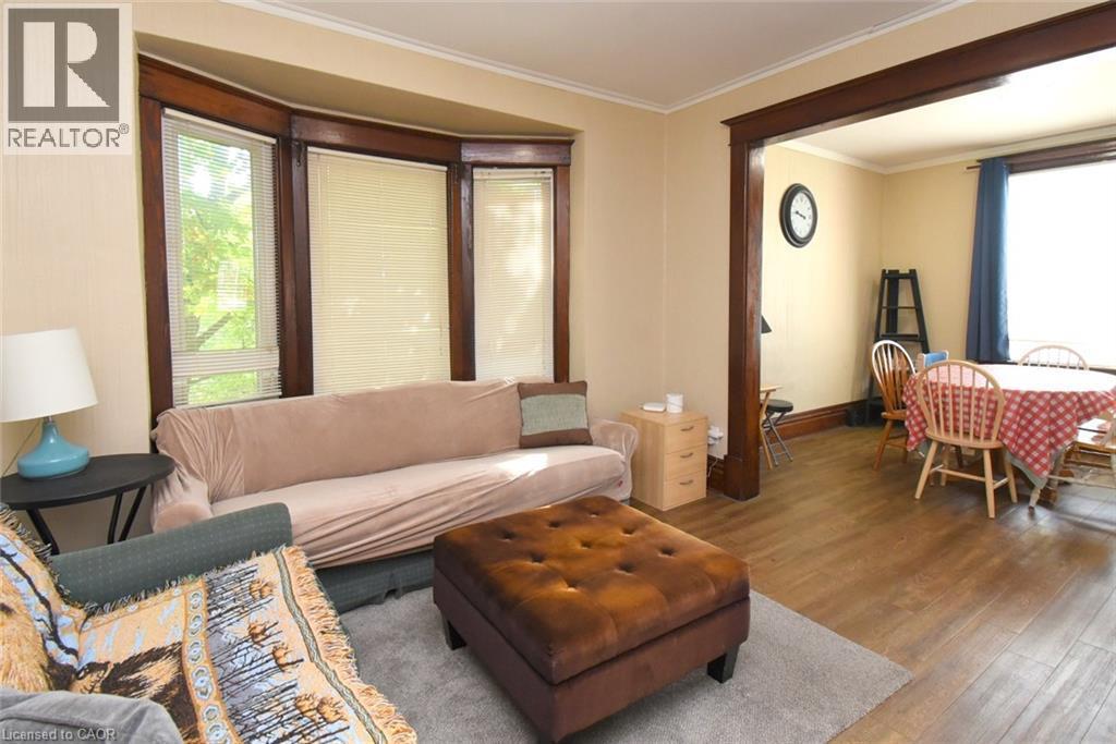 Bay window with wood trim, wood-finish flooring, and crown molding - 734 King Street W, Hamilton, ON