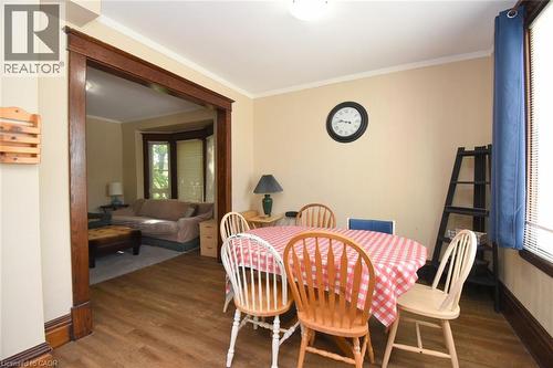 Dining area featuring wood-finish flooring, a ceiling-mounted light fixture, and crown molding - 734 King Street W, Hamilton, ON 