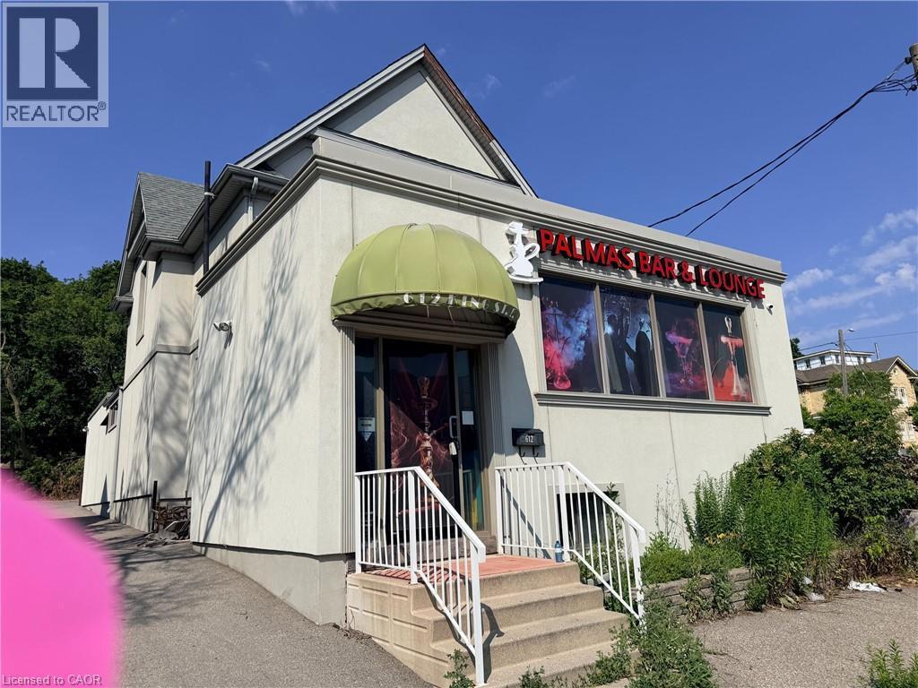 Stucco exterior with a peaked roof - 612 King Street E, Kitchener, ON