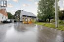 Asphalt driveway with a fenced property line, wood siding, and mature trees - 102 Stewart Avenue, Cambridge, ON 