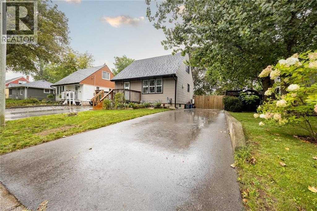 Paved driveway, manicured lawn, established landscaping, and wood privacy fence - 102 Stewart Avenue, Cambridge, ON