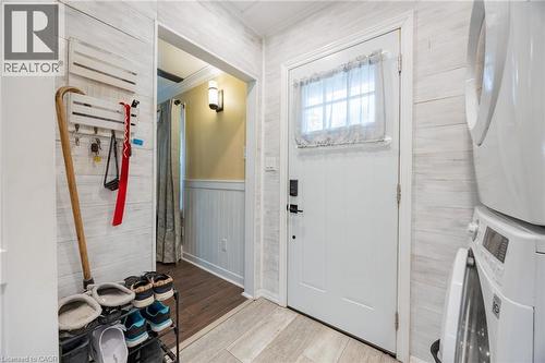 Shiplap wall paneling, light wood-finish flooring, white paneled door with window, and a built-in light fixture - 102 Stewart Avenue, Cambridge, ON 