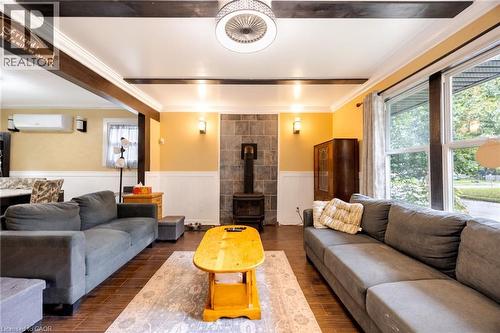 Wood-finish flooring, exposed ceiling beams, and a gas fireplace - 102 Stewart Avenue, Cambridge, ON 