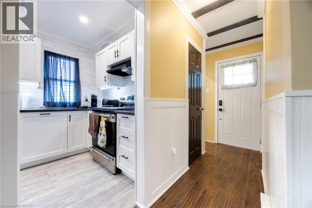 White cabinetry, dark countertops, and stainless steel range - 102 Stewart Avenue, Cambridge, ON