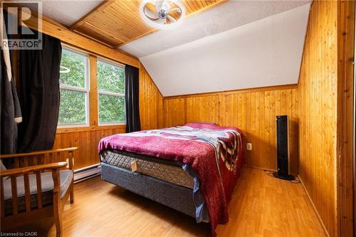 Wood-finish flooring, wood-paneled walls, and a wood-paneled ceiling with a ceiling fan - 102 Stewart Avenue, Cambridge, ON 