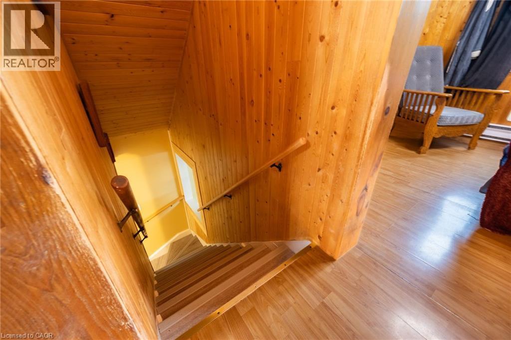 Wood-paneled staircase with natural wood handrails, complemented by wood-finish flooring - 102 Stewart Avenue, Cambridge, ON