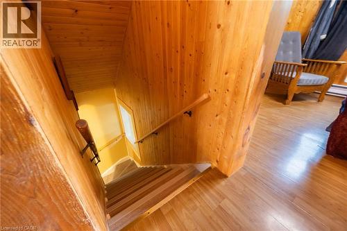 Wood-paneled staircase with natural wood handrails, complemented by wood-finish flooring - 102 Stewart Avenue, Cambridge, ON 