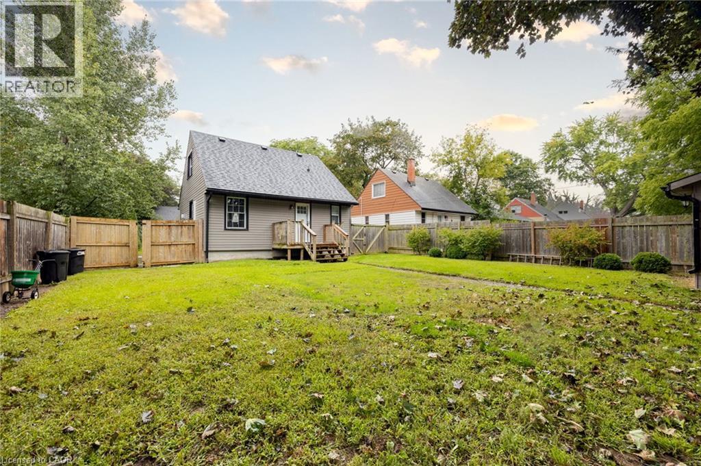 Expansive grassy yard with mature perimeter trees and a wood fence - 102 Stewart Avenue, Cambridge, ON