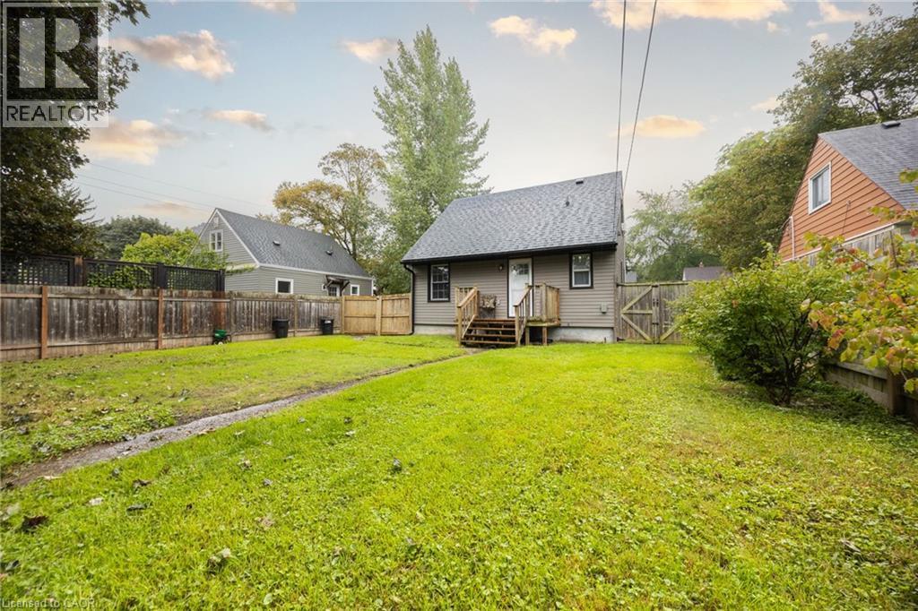 Expansive backyard with a manicured lawn, established landscaping, and perimeter fencing - 102 Stewart Avenue, Cambridge, ON