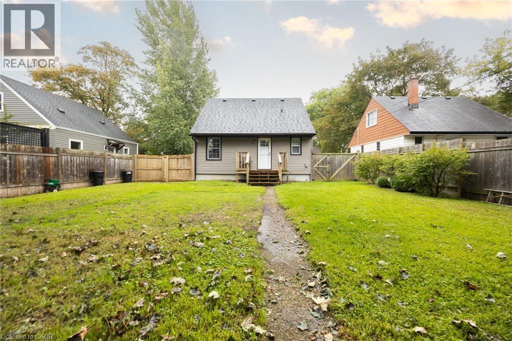 Expansive backyard featuring a manicured lawn, established privacy fencing, and mature trees - 102 Stewart Avenue, Cambridge, ON