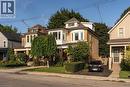 Brick exterior with white trim, multiple bay windows, dormer windows, and a paved driveway - 50 Norway Avenue, Hamilton, ON 