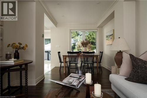 Dark wood-finish flooring throughout, crown molding detailing, recessed lighting, and a large window - 50 Norway Avenue, Hamilton, ON 