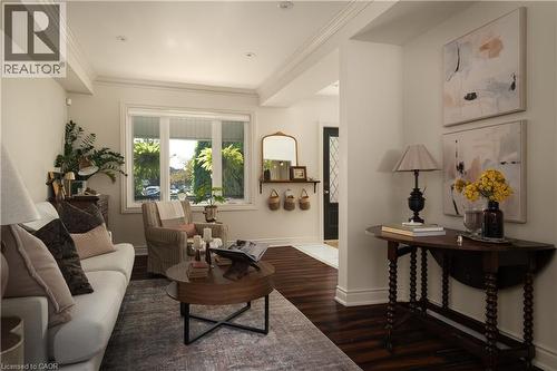 Dark wood-finish flooring complemented by white crown molding - 50 Norway Avenue, Hamilton, ON 