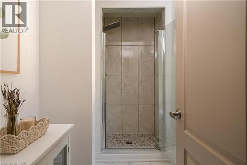 Walk-in shower with full-height tile surround, glass enclosure, and pebble-style floor - 50 Norway Avenue, Hamilton, ON 
