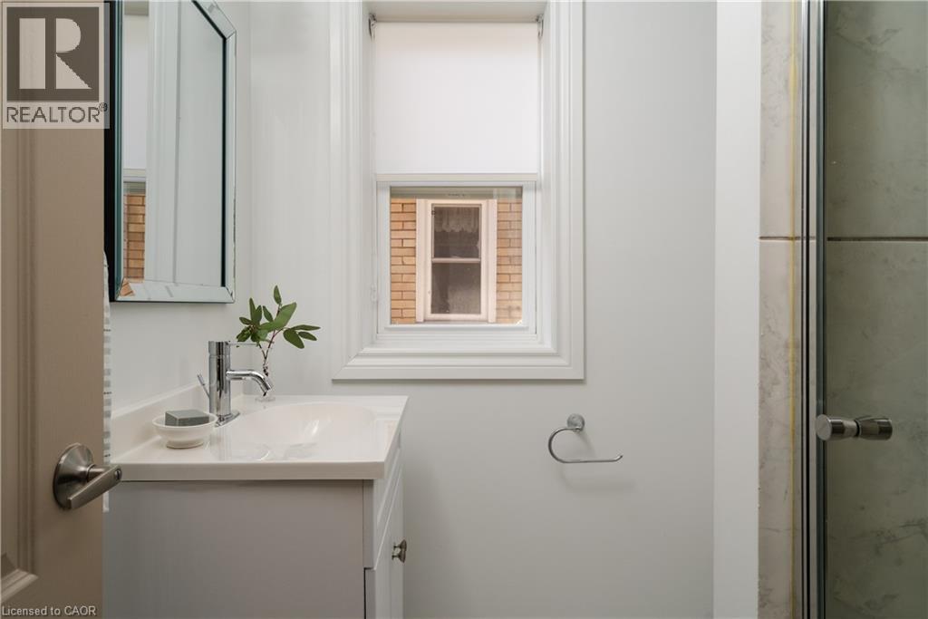 White vanity with an integrated sink and chrome faucet - 50 Norway Avenue, Hamilton, ON