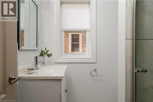White vanity with an integrated sink and chrome faucet - 50 Norway Avenue, Hamilton, ON 
