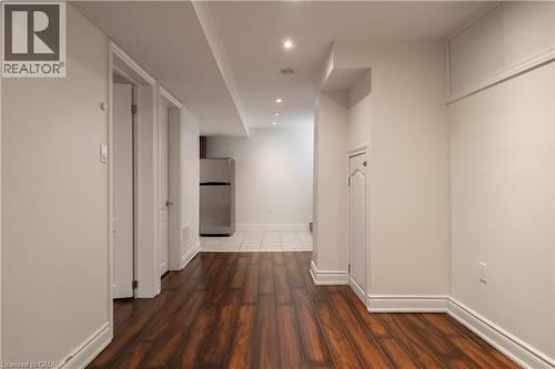 Wood-finish flooring, recessed lighting, white interior doors, and a stainless steel refrigerator - 50 Norway Avenue, Hamilton, ON 