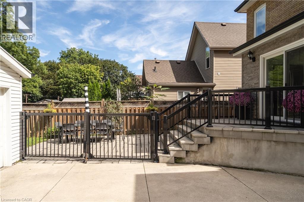 Concrete patio with direct access to a private, fenced yard featuring paver stones - 50 Norway Avenue, Hamilton, ON